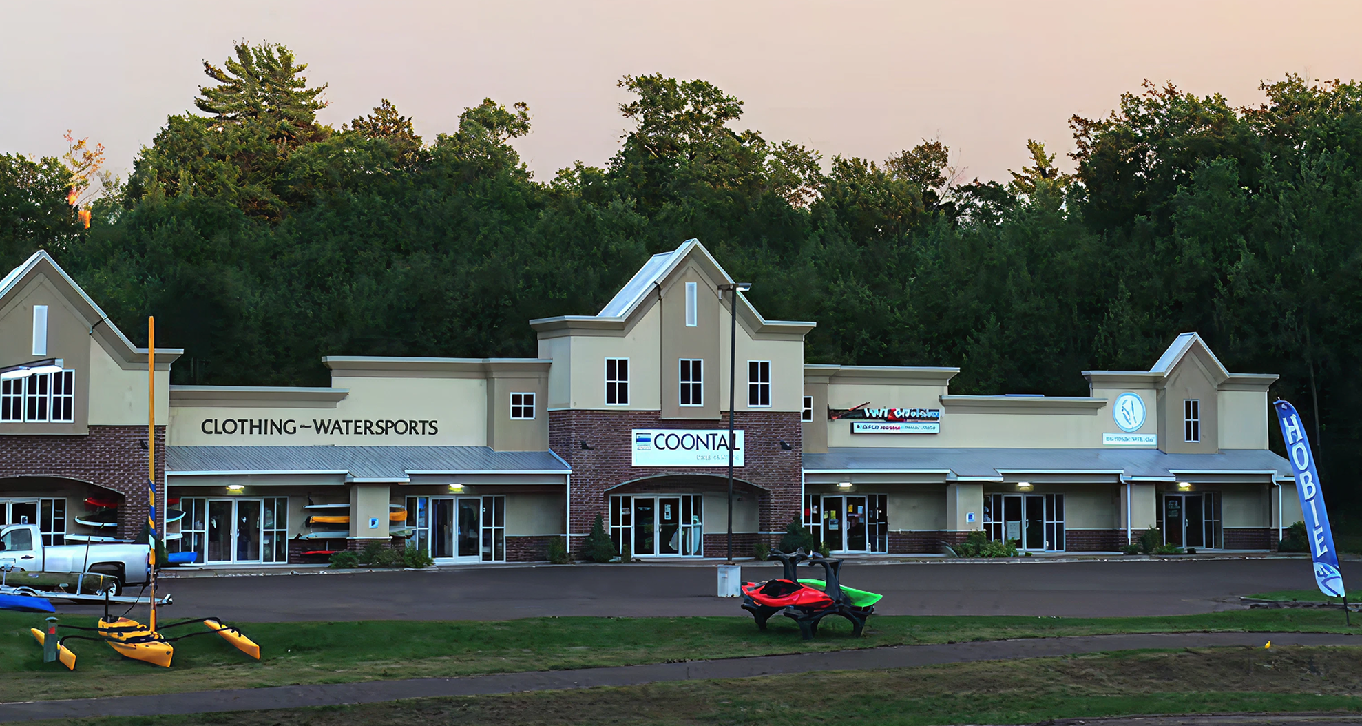 Commercial building with various businesses including a clothing store and watersports equipment.