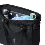 A black tote bag shown open, filled with a laptop, two water bottles, and a blue knit blanket, on a white background. The bag has a small deer logo and the brand name 'campmule' printed near the bottom front.