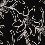 Close-up of the Esqualo Flower Embroidery Dress in Black highlighting the intricate floral embroidery and textured fabric
