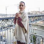 Woman wearing EsQualo Knit Turtleneck Poncho in Biscuit with jeans, showing the relaxed front fit