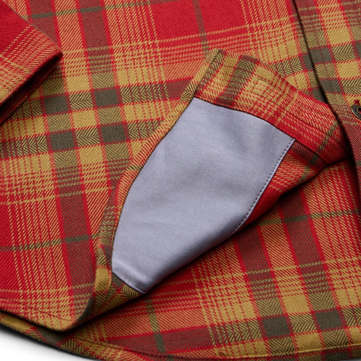 Detailed view of the microfiber and plaid pattern on Howler Brothers Harker’s Flannel in Brick