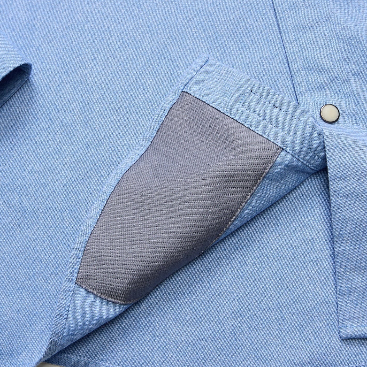 Detail of Howler Brothers Men's Crosscut Deluxe Longsleeve microfiber sunglass cleaner in Fanned Flora Faded Blue Oxford