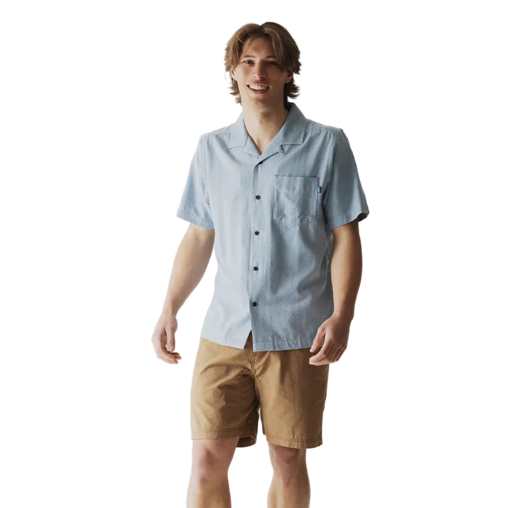 Full-body view of a man wearing the KAVU Deckhouse Short Sleeve Shirt in Tropical Fog for travel, outdoor gatherings, and everyday wear