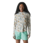 Full-body view of a woman wearing the KAVU Sunshade Hoody in Mod Mix for hiking, paddling, travel, and sunny outdoor adventures