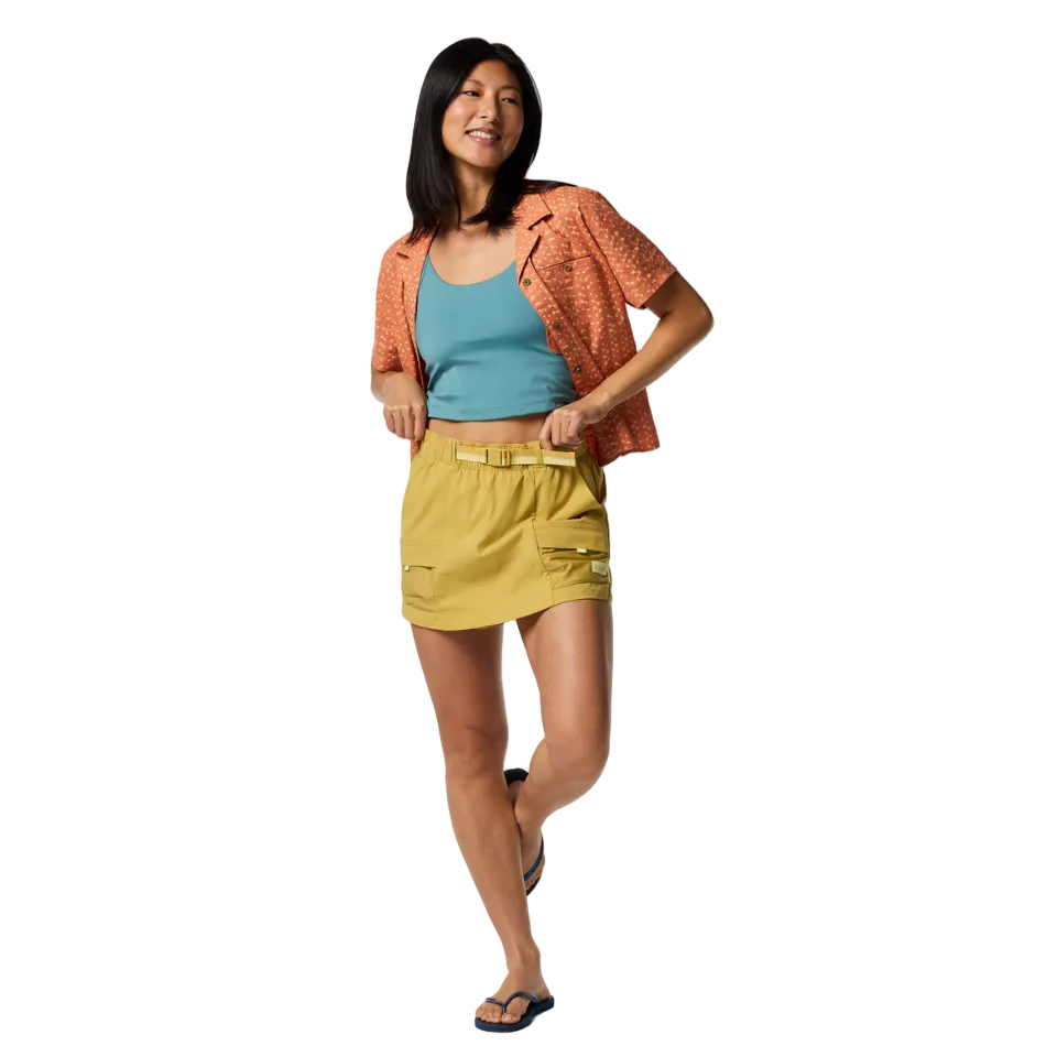 Woman wearing cotopaxi brinco skirt in husk with blue and orange top
